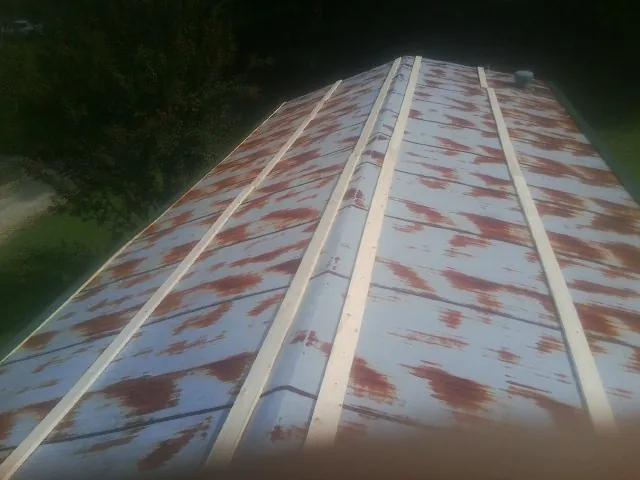 Rusted metal roof panels with new wood purlins before replacement — Storm Damage Roof Repair in Dalbo by Roofing Brothers