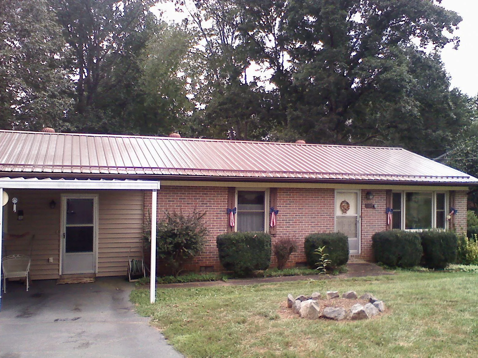 Bronze metal roof and carport on a brick ranch home — Roof Repair work by our crew in Dalbo